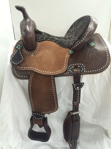 Chic and western this custom barrel saddle rocks the look. Hand tooled feathers with white buck stitch on chocolate leather and custom turquoise conchos make th
